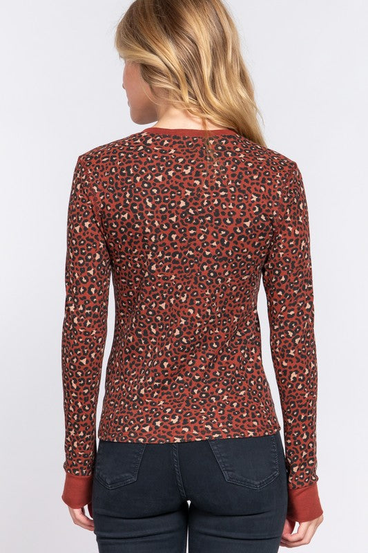 Person wearing a red leopard print long-sleeve top on a white background