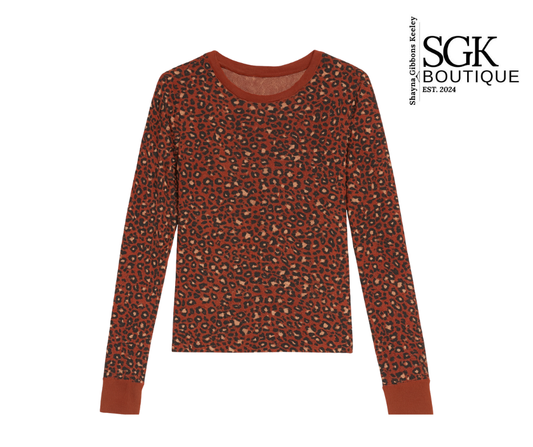 Red long-sleeve shirt with a subtle pattern on a white background, featuring the SGK Boutique logo.