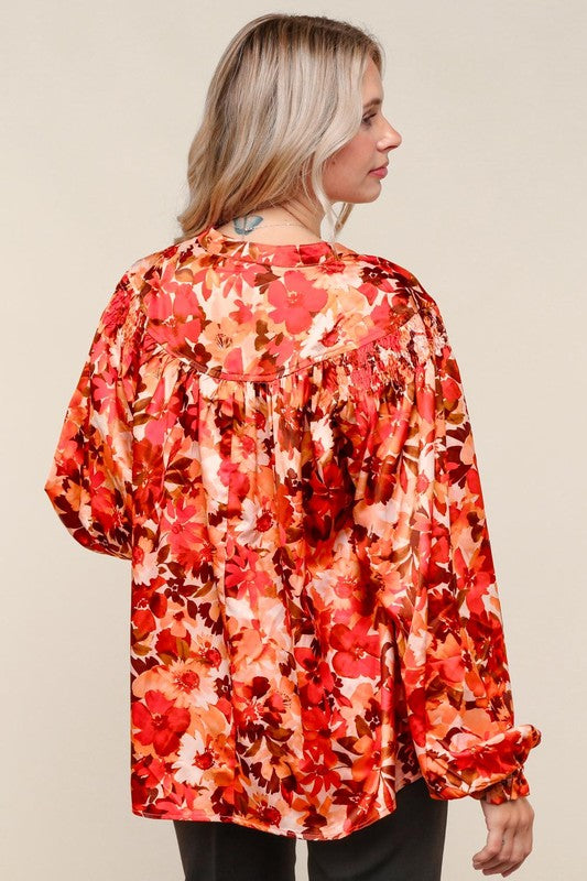 Woman wearing a red floral blouse against a beige background