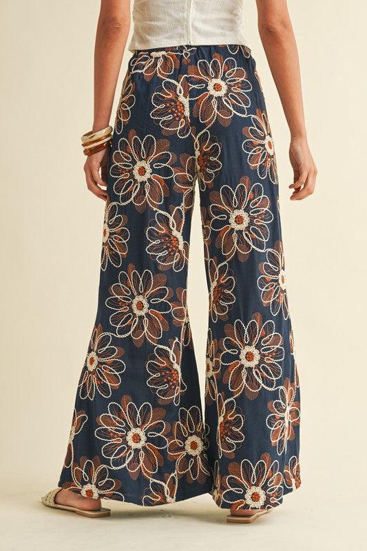 Floral-patterned pants worn by a person on a beige background