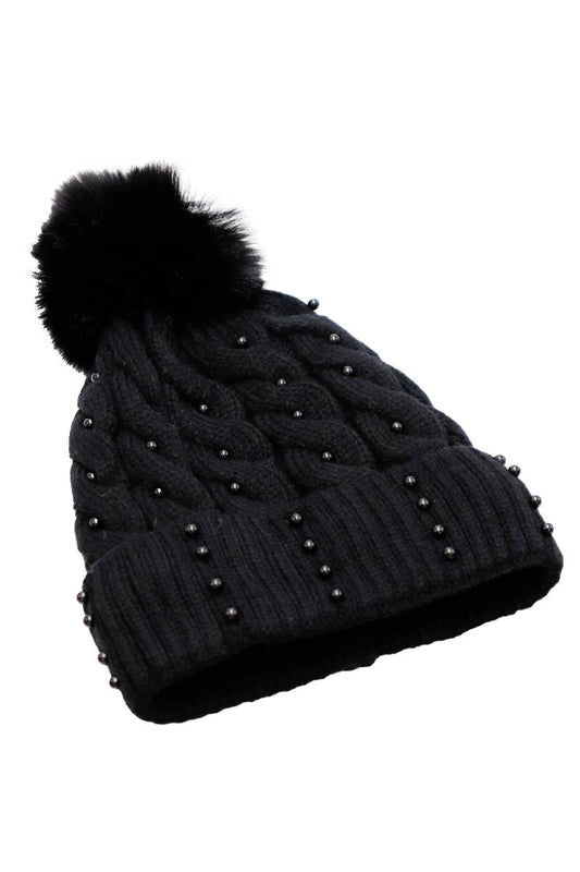 Black knit beanie with faux fur pom-pom and pearl embellishments on a white background