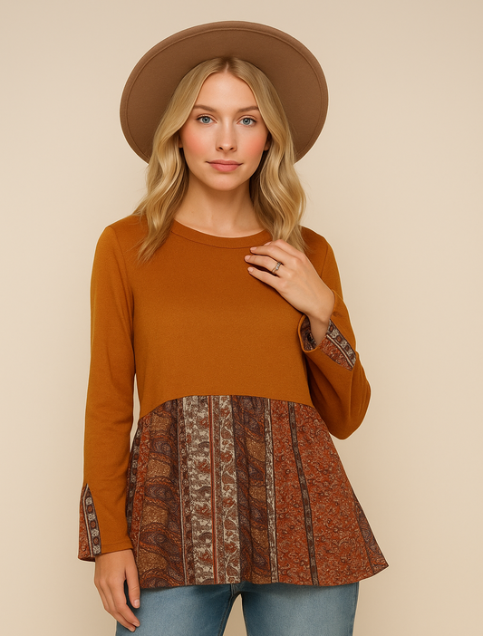 Woman wearing a rust-colored top with a patterned bottom half on a beige background