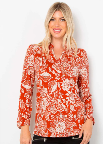 Woman wearing a brick floral blouse against a white background