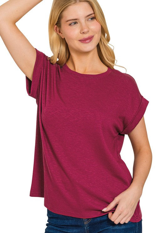 Woman wearing a maroon t-shirt with a plain background