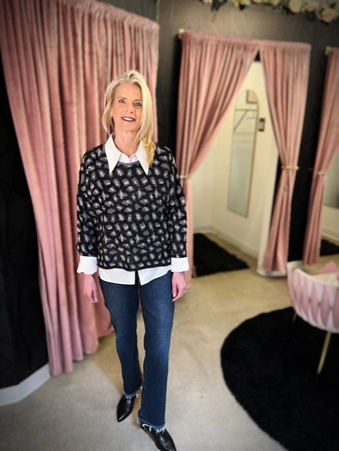 Woman standing in a room with pink curtains and a mirror.