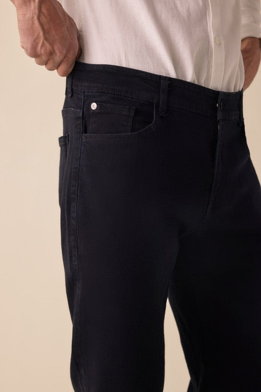 Person wearing black pants with a beige background