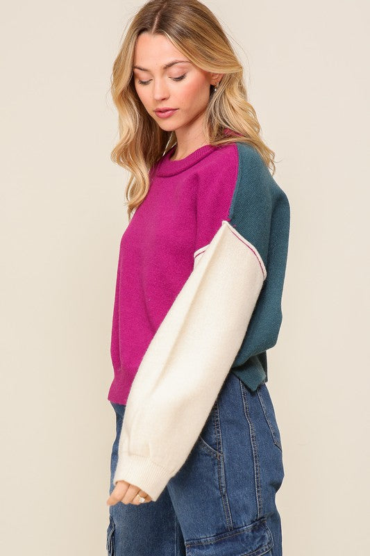Woman wearing a colorful sweater with a plain background