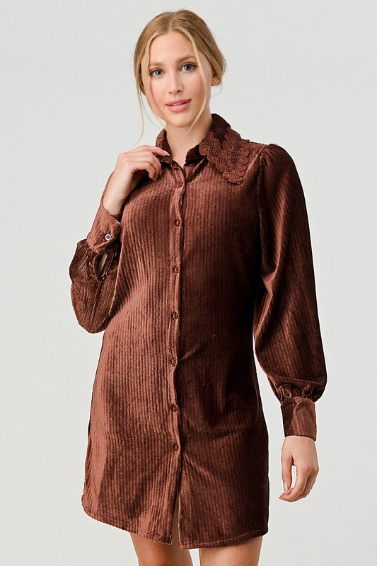 Woman wearing a brown corduroy dress against a plain background