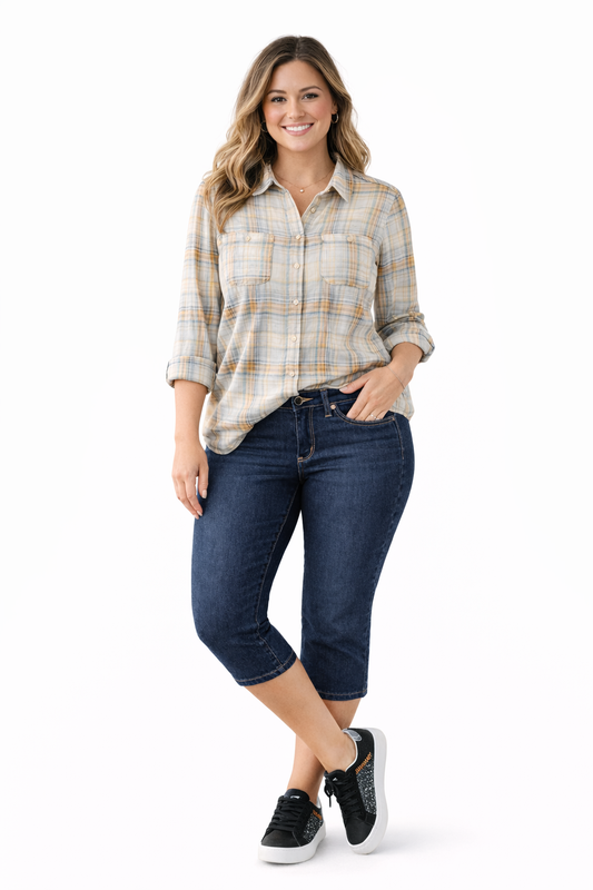 Woman wearing a plaid shirt and dark rinse capri jean on a white background