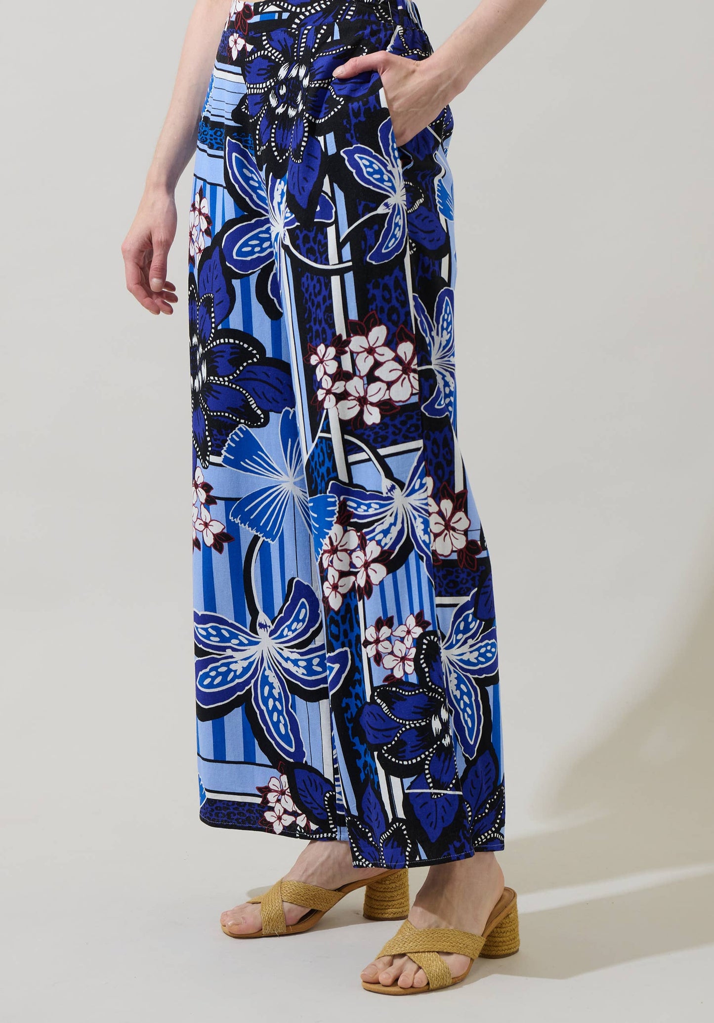 Person wearing a blue floral patterned skirt on a plain background