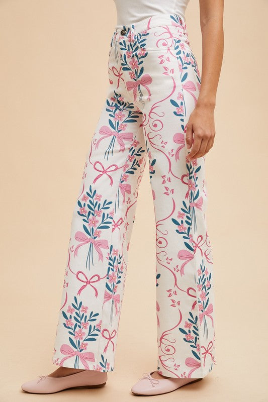 Floral and bow-patterned pants worn by a person on a beige background