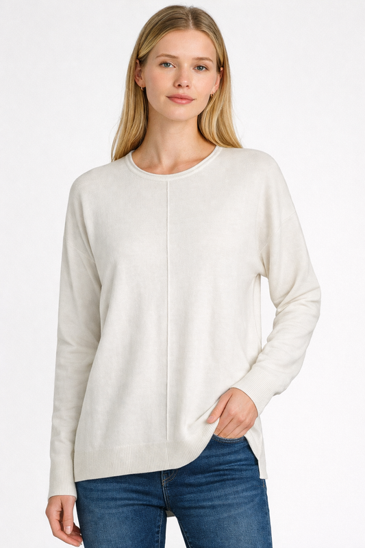 Woman wearing a white sweater and blue jeans on a white background