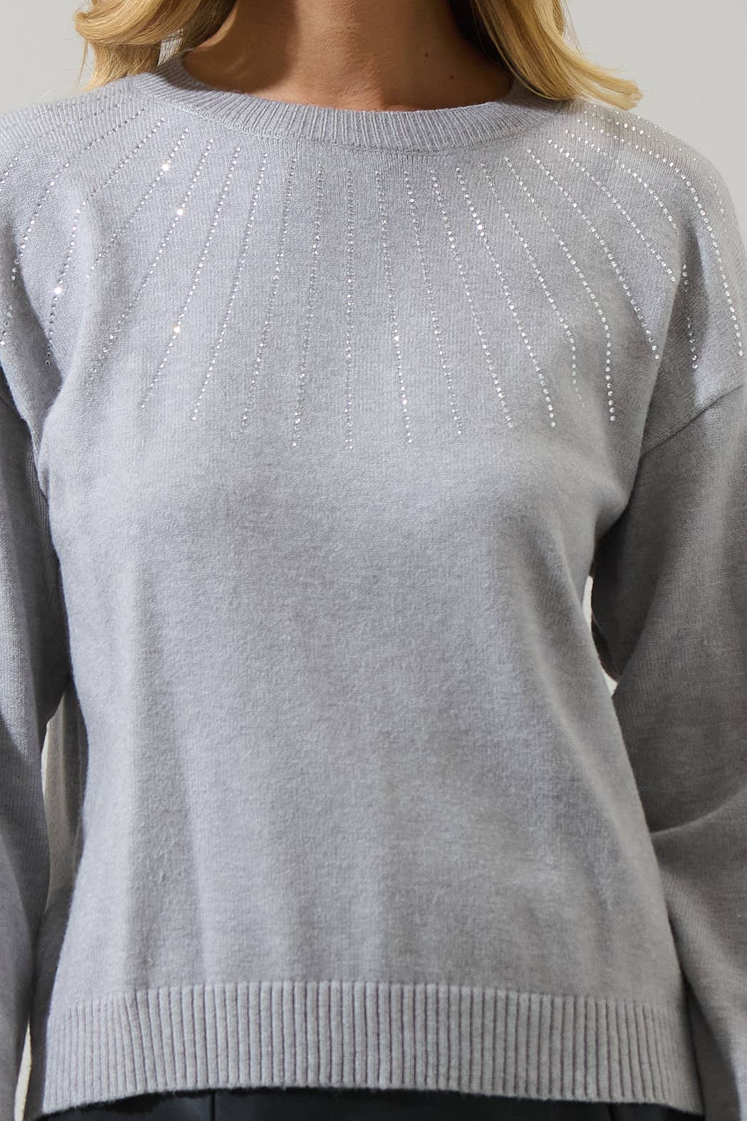 Gray sweater with decorative elements on a neutral background
