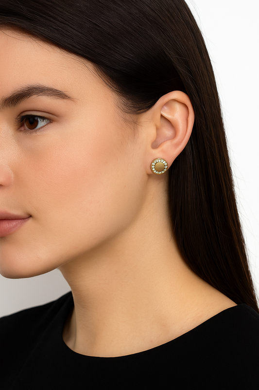 Close-up of a woman wearing gold earrings with a white background