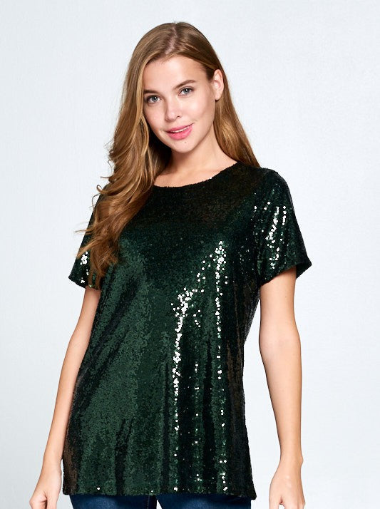 Woman wearing a huntergreen sequin top against a white background