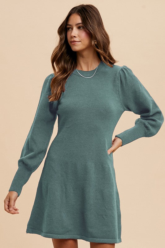 Woman wearing a teal dress against a beige background