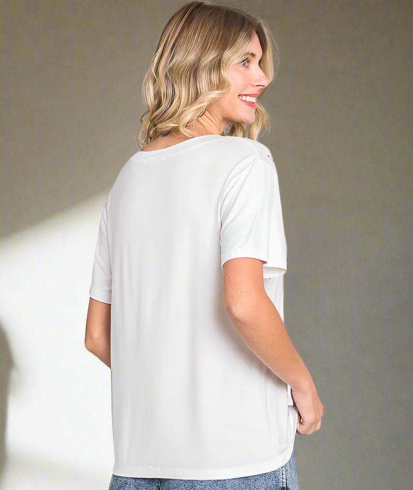 Woman wearing a white t-shirt and denim shorts on a plain background