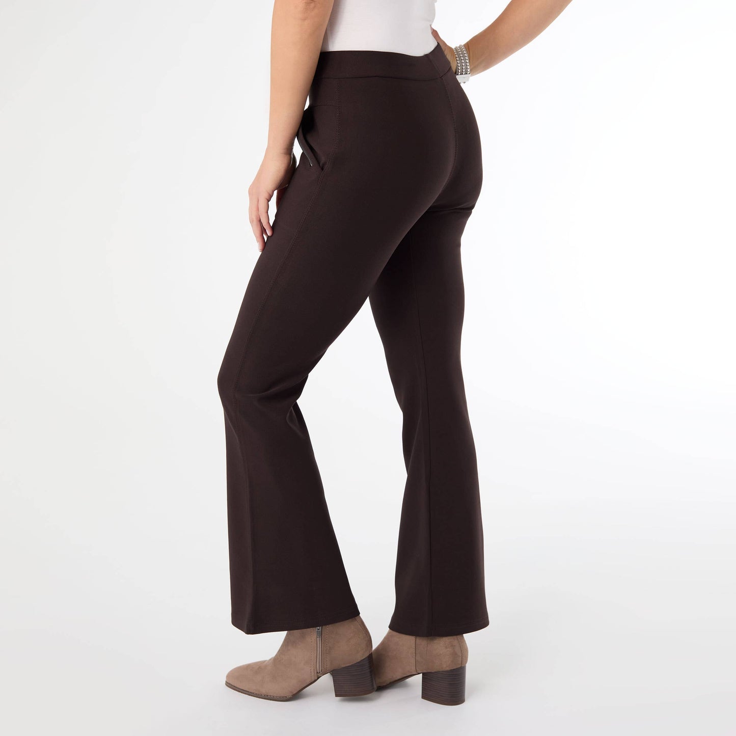 Brown flared pants worn by a person on a white background