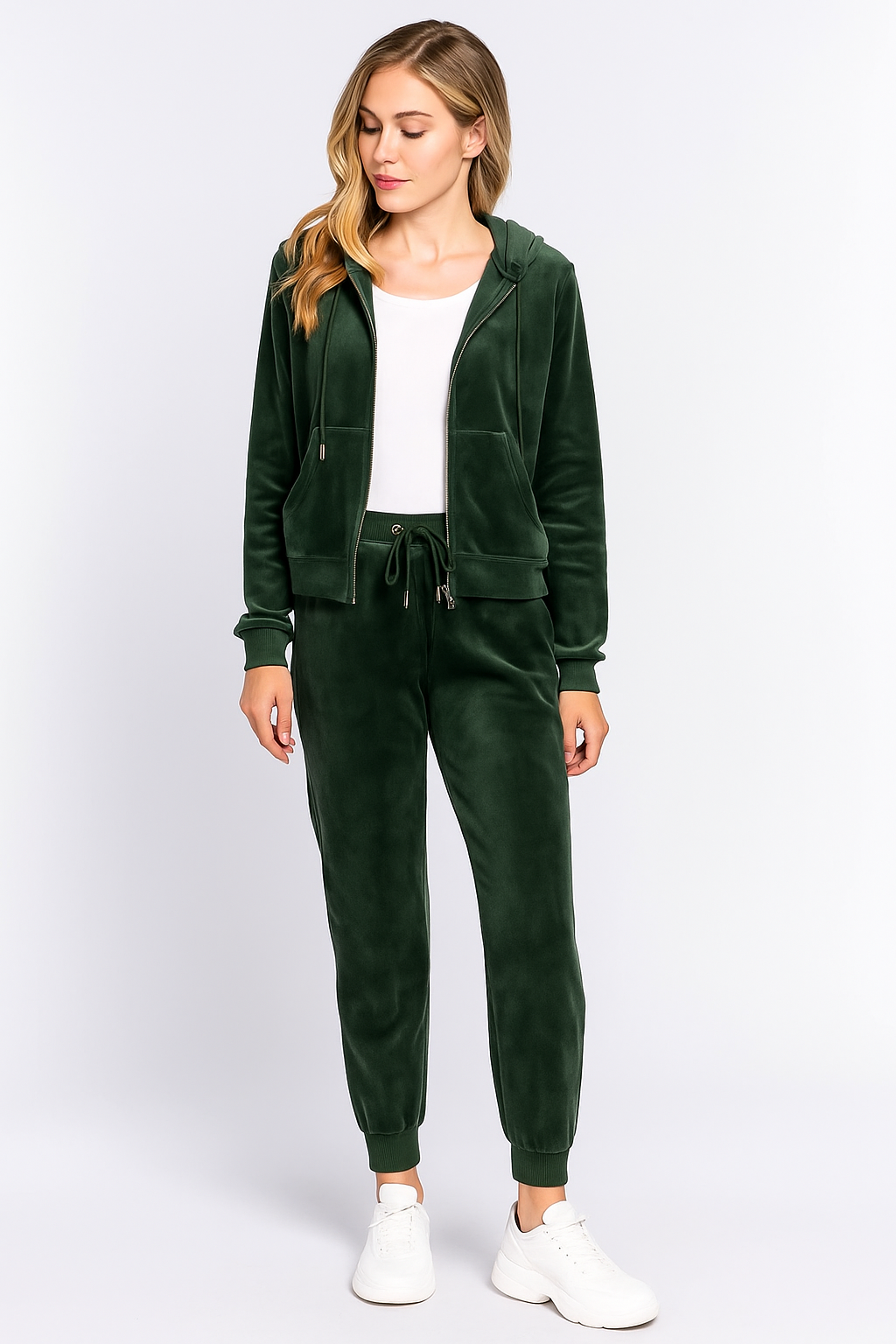 Woman wearing a green tracksuit with a white top on a white background