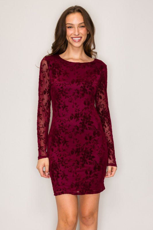 Woman wearing a burgundy floral dress against a plain background