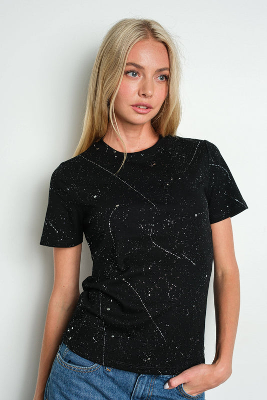 Woman wearing a black t-shirt with pattern against a plain background