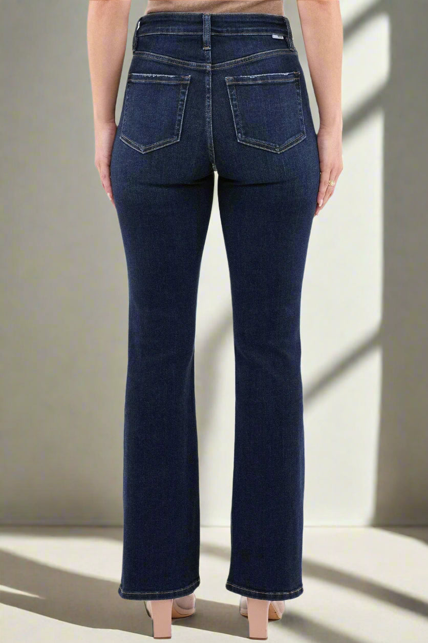 Dark blue jeans worn by a person on a white background