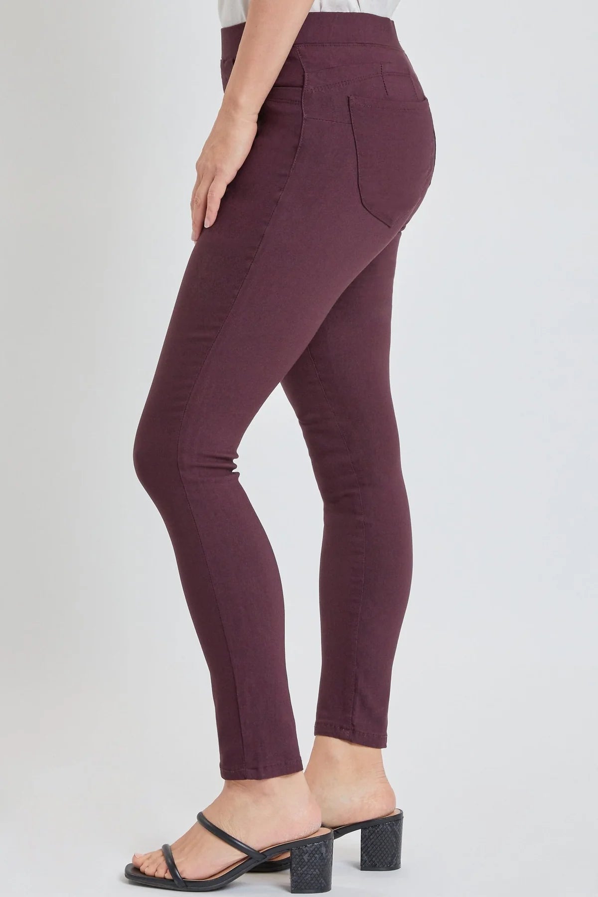 Maroon pants worn by a person on a white background