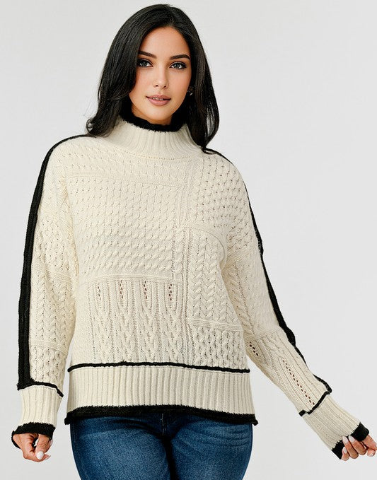 Woman wearing a cream sweater with black accents on a white background