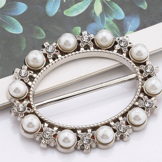 Decorative shirt ring with pearls and crystals on a white background