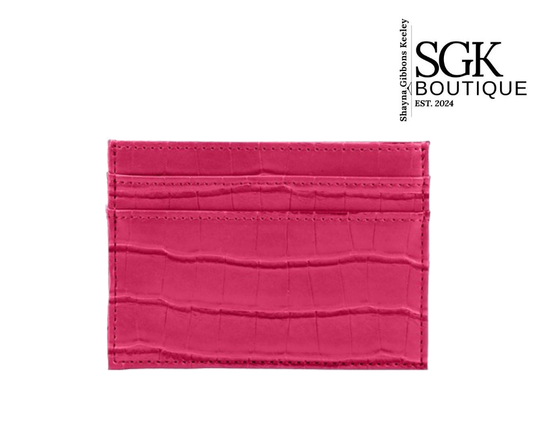 Pink crocodile-textured cardholder with SGK Boutique branding on a white background