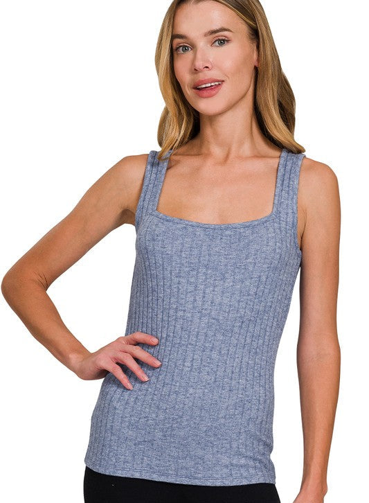 Woman wearing a light navy tank top on a white background