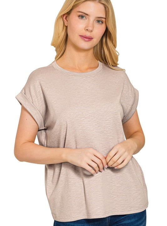 Woman wearing a beige t-shirt and blue jeans on a white background