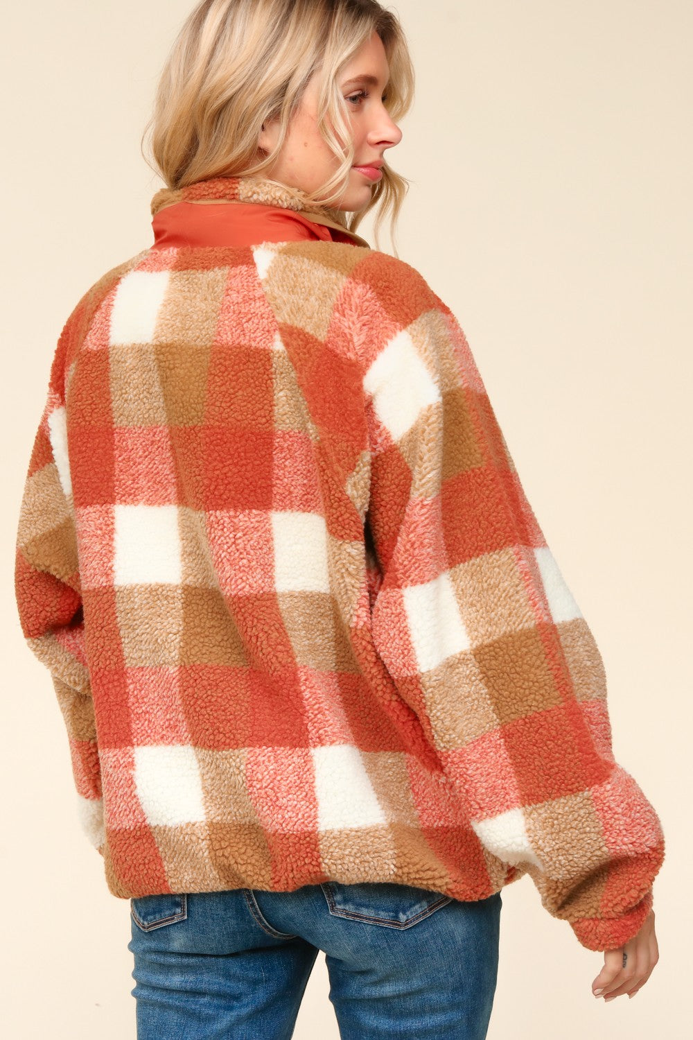 Woman wearing a plaid shirt with a neutral background