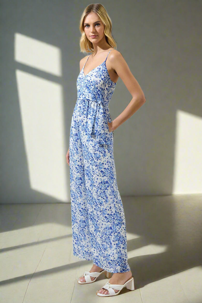 Woman wearing a blue floral dress against a plain background