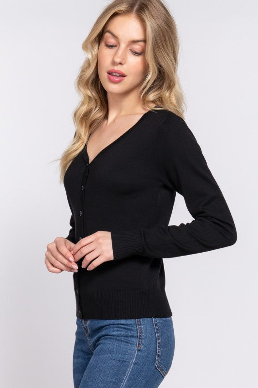 Woman wearing a black long-sleeve top and blue jeans on a white background