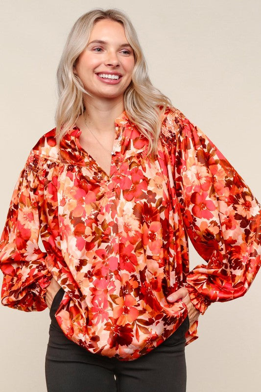 Woman wearing a red floral blouse against a beige background