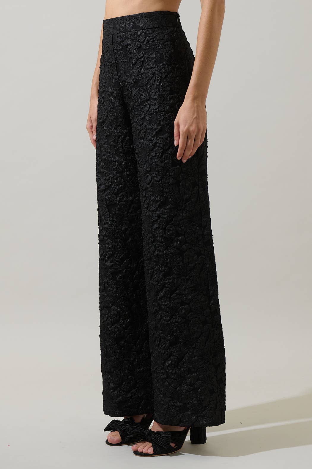 Black textured wide-leg pants worn by a person on a plain background