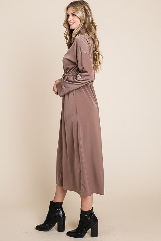 Woman wearing a brown dress with a belt on a beige background