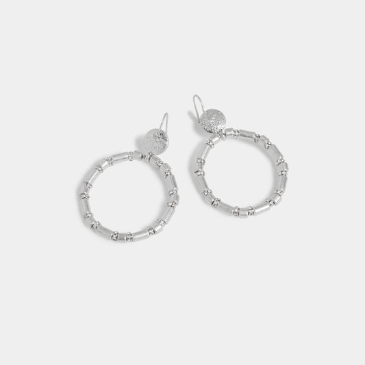 Silver hoop earrings on a light gray background
