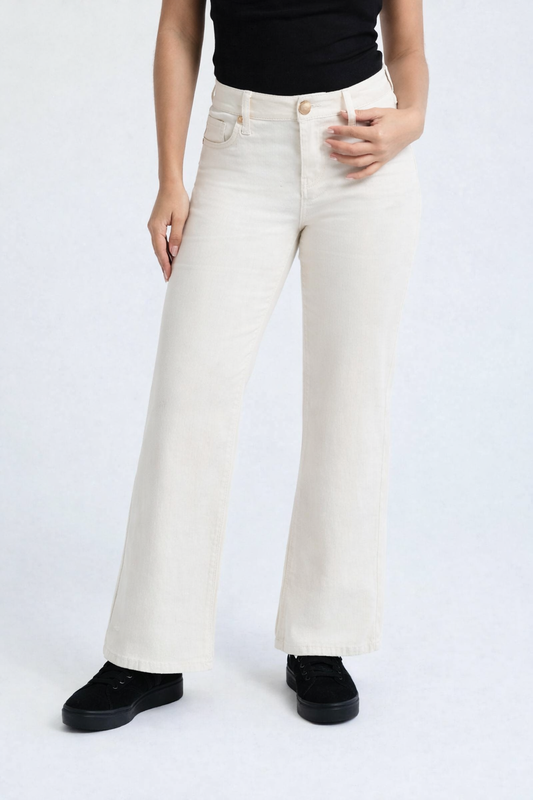 Person wearing smoke white flared jeans and black shoes on a white background