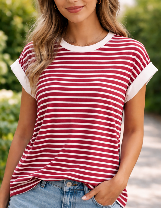 Person wearing a red and white striped shirt with blue jeans outdoors.