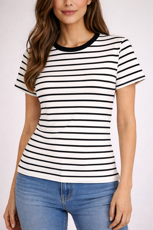 Woman wearing a black and white striped t-shirt with blue jeans on a plain background