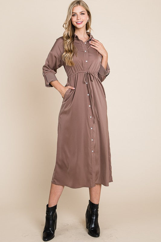 Woman wearing a brown dress with a beige background