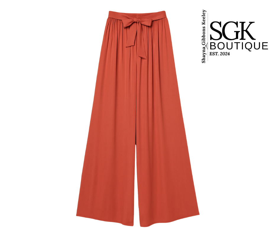 Rust wide-leg pants with a bow detail on a white background, featuring the SGK Boutique logo.