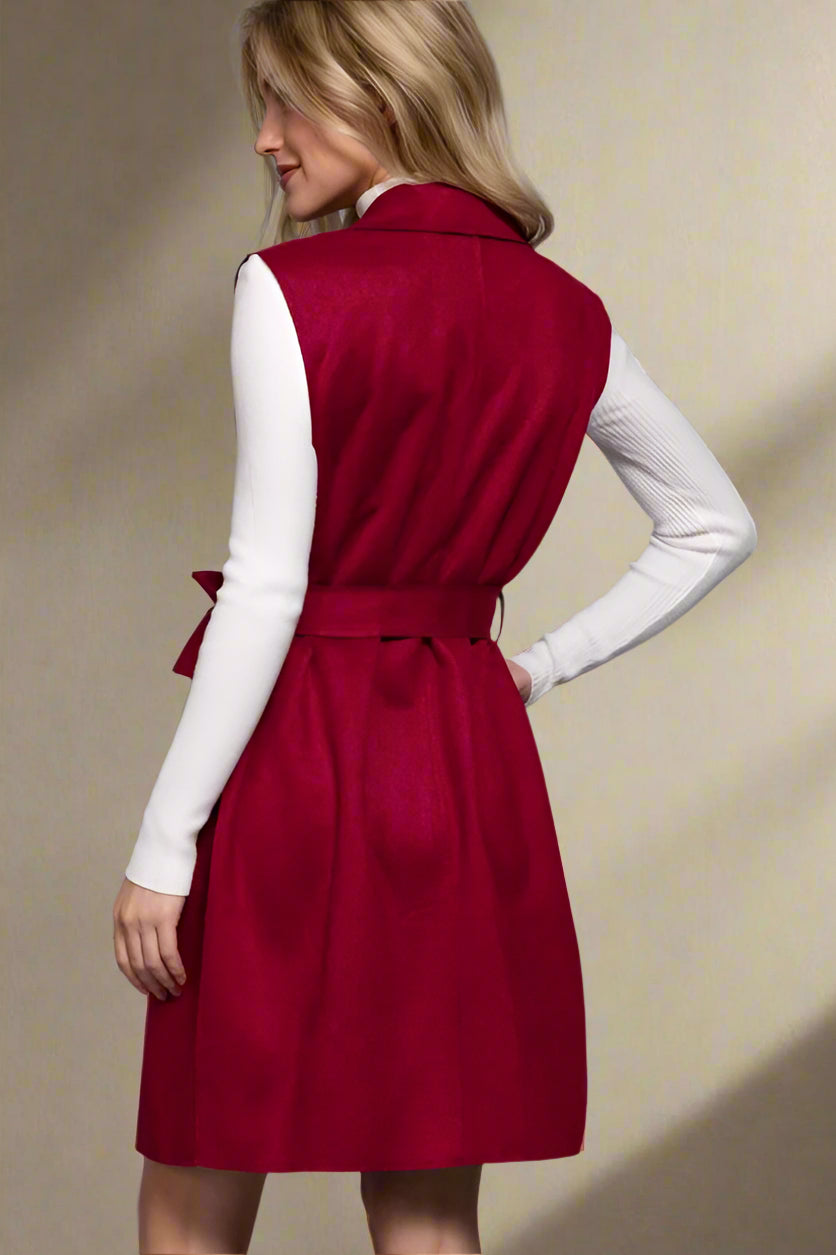Woman wearing a red dress over a white long-sleeve shirt against a neutral background