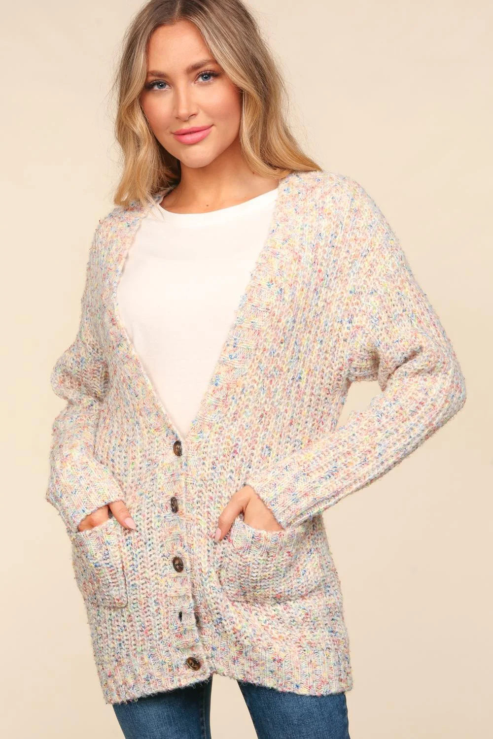 Woman wearing a multicolored cardigan over a white shirt on a beige background
