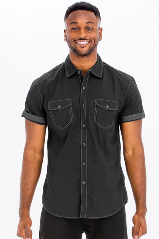 Man wearing a black short-sleeve button-up shirt on a white background