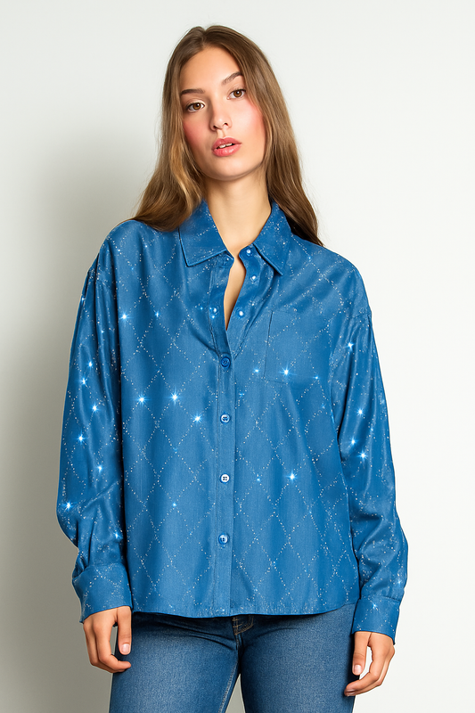 Woman wearing a blue patterned shirt against a plain background