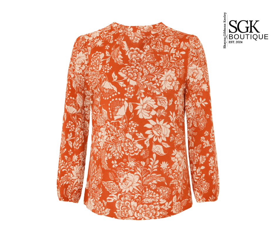 Orange floral patterned blouse on a white background with SGK Boutique logo.