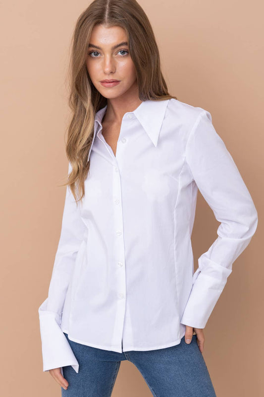 Woman wearing a white shirt and blue jeans against a beige background